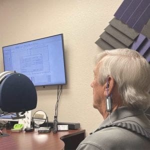 A man has his hearing aids programmed using real ear measurement as a part of hearing aid service and repair